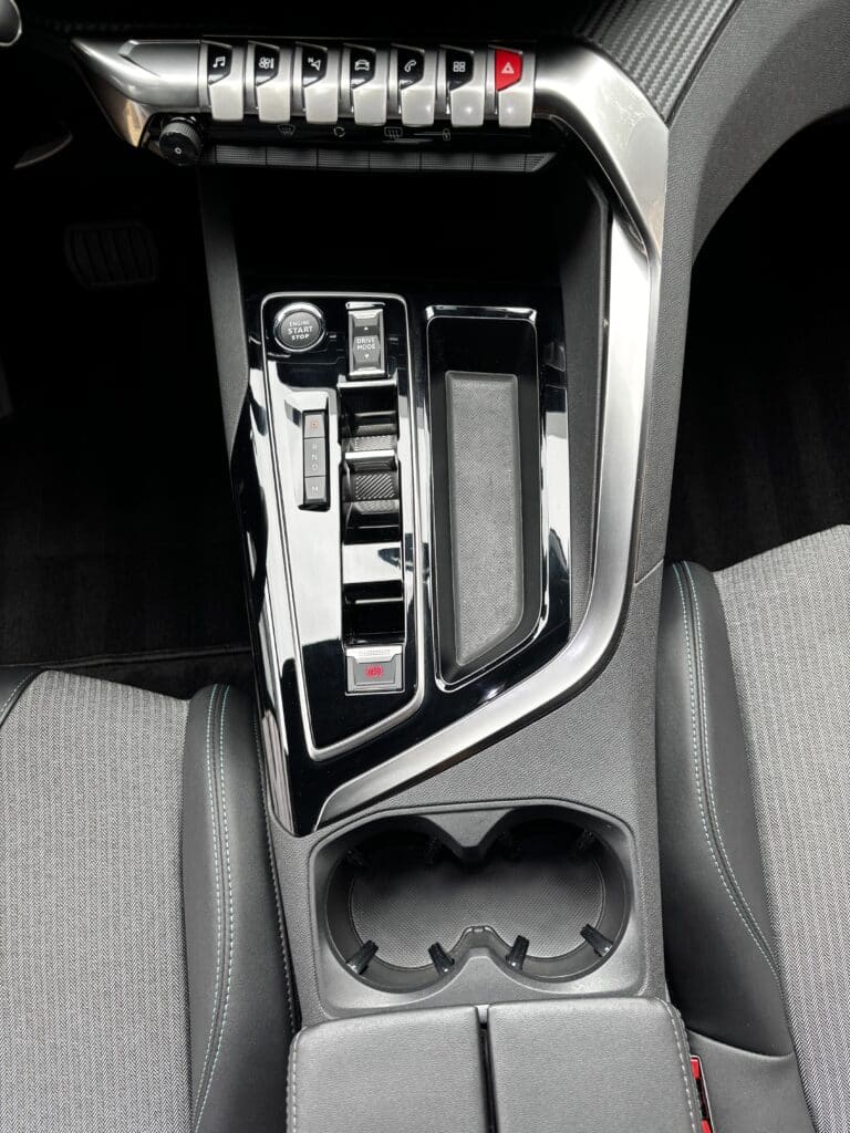 Console centrale noire voiture, sélecteur auto et i-Cockpit. Console centrale noire brillante de voiture. Commandes i-Cockpit, sélecteur de vitesse, bouton Engine Start Stop et frein à main électrique.