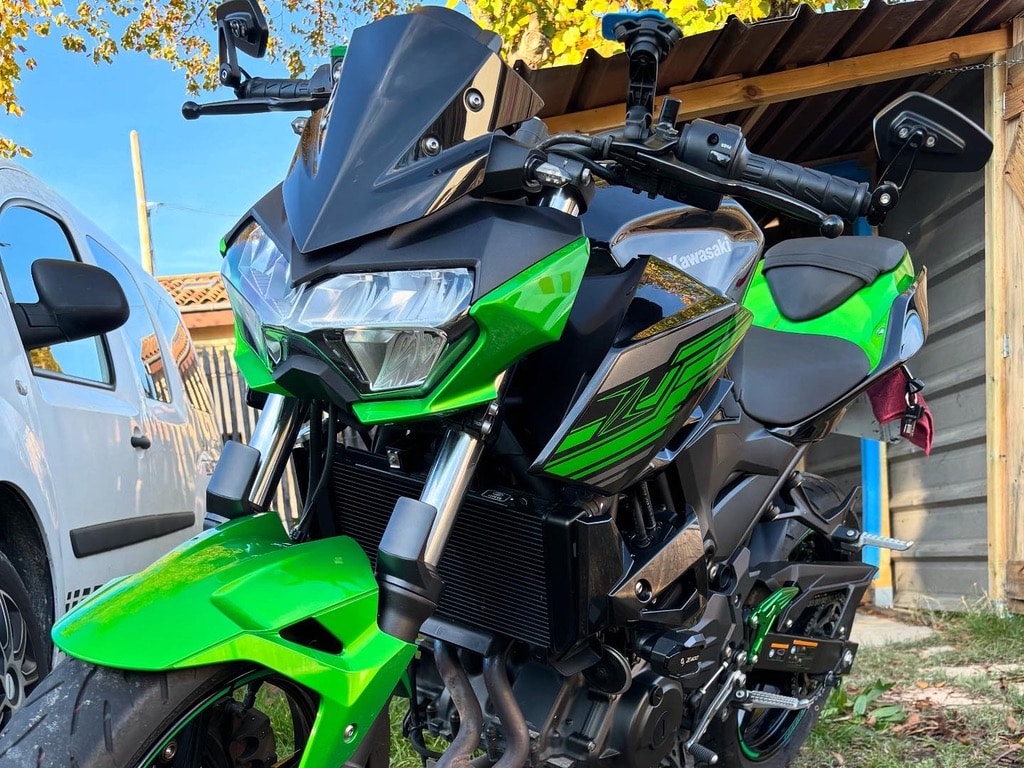 Kawasaki Z moto naked sportive verte et noire Moto Kawasaki Z verte et noire. Gros plan sur la face avant musclée, phare LED, carénage vert vif, rétroviseurs sportifs.